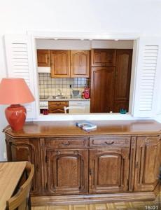 a kitchen with wooden cabinets and a table with a lamp at Appartement 60m2- vue sur la montagne in Crans-Montana