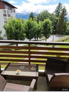 una mesa y sillas en un balcón con vistas en Appartement 60m2- vue sur la montagne, en Crans-Montana