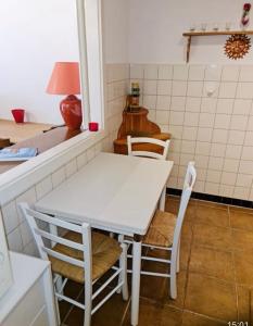 einen weißen Tisch und Stühle in der Küche in der Unterkunft Appartement 60m2- vue sur la montagne in Crans-Montana