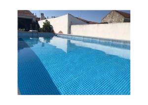 - une grande piscine revêtue de carrelage bleu dans l'établissement Pias Guesthouse, à Pias