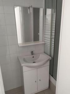 a white bathroom with a sink and a mirror at Villette in Aubervilliers
