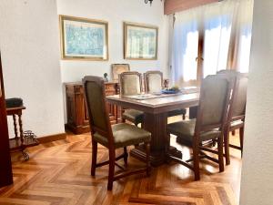 a dining room table with chairs and a mirror at Chalet al lado de la playa con piscina privada, jardín y barbacoa, frontón, 6 HABITACIONES in Laredo