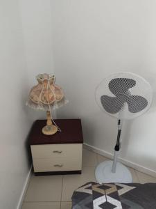 - une chambre avec une table, une lampe et une commode dans l'établissement Villette, à Aubervilliers