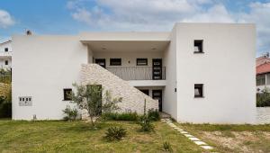 a white house with a triangular roof at Sea Melody in Lopar