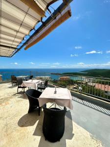 a patio with tables and chairs and a view of the ocean at Montenegrina Apartment in Budva