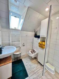 uma casa de banho branca com um lavatório e um WC em Fewo Plüschmors em Dornum