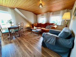 a living room with a couch and a table at Fewo Plüschmors in Dornum