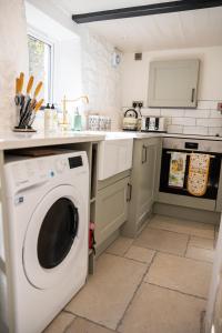 a kitchen with a white washing machine in a kitchen at 2 Candlemas Cottage in Bourton on the Water