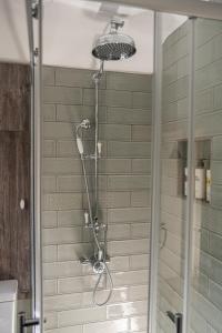 a shower with a shower head in a bathroom at 2 Candlemas Cottage in Bourton on the Water