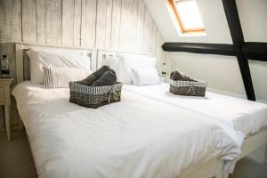 a large white bed with baskets on top of it at 2 Candlemas Cottage in Bourton on the Water