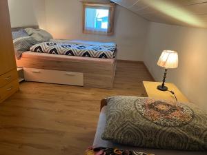 um pequeno quarto com 2 camas e um candeeiro em Historische Maisonette-Wohnung mit Gästekarte und Ermässigungen em Naters