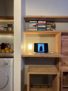 - un ordinateur portable installé sur un bureau en bois dans la cuisine dans l'établissement Heaven AT 11, your Deluxe Studio with personal bathroom, kitchenette & terrace, à Gand