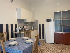 eine Küche mit einem Tisch und einem weißen Kühlschrank in der Unterkunft Vista Lago Bacoli in Bacoli