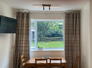 a table and chairs in front of a window at King Studio Apartment with Garden and Parking in Ealing