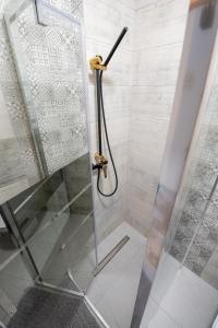 a shower stall with a glass door and a shower at Apartamenty u Symuna in Zakopane