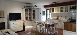 a kitchen with white cabinets and a table and chairs at Juli's Place in Rovinjsko Selo
