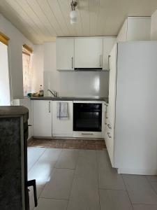 uma cozinha com armários brancos e um frigorífico em Historische Maisonette-Wohnung mit Gästekarte und Ermässigungen em Naters