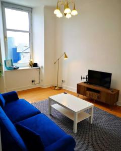a living room with a blue couch and a coffee table at The Snug in Dunoon