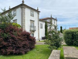 a large white building with a balcony in a yard at Quinta do Monteverde in Viana do Castelo