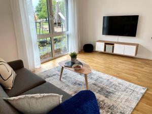 ein Wohnzimmer mit einem Sofa und einem Tisch in der Unterkunft Neubau – S-Bahn nah – Köln Messe/Hbf in Bergisch Gladbach