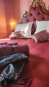 a bedroom with two beds with red sheets and pillows at Hotel Zia Piera in Chiavari