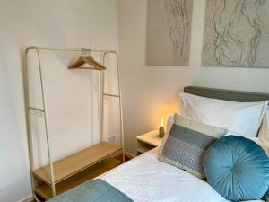 a bedroom with a bed with a blue pillow on it at Neubau – S-Bahn nah – Köln Messe/Hbf in Bergisch Gladbach