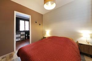 ein Schlafzimmer mit einem roten Bett und einem Fenster in der Unterkunft Le saut du cerf (ferme du sotré) in Gérardmer
