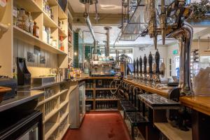 a kitchen with a bar with lots of wine bottles at The Old Cannon Brewery in Bury Saint Edmunds