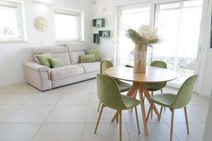 un soggiorno con tavolo e sedie verdi di Calypso Luxury Pool&Spa a Pula