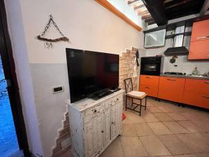 a kitchen with a large flat screen tv on the wall at La Casina - Borgo di Bibbona in Bibbona