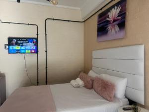 un osito de peluche sentado en una cama en un dormitorio en Affordable Guest Room @260Main en Johannesburgo