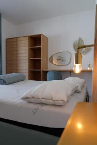 una camera da letto con un letto con cuscini bianchi e un tavolo di Calypso Luxury Pool&Spa a Pula