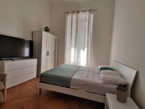 um quarto com uma cama, uma televisão e uma janela em Casa Vacanze Trieste Piace em Trieste