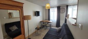 a living room with a couch and a table at La p'tite maison in Londinières