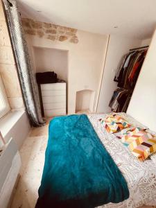 Un dormitorio con una cama con una manta azul. en Domus de la Pierre en Autun