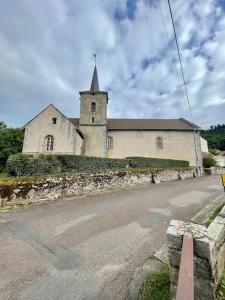 an old church with a steeple on the side of a road at Domus de la Pierre in Autun +9 photos