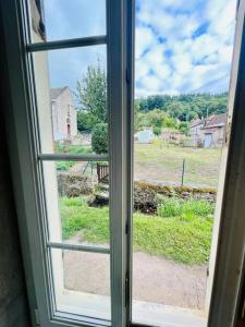 una ventana abierta con vistas a un campo en Domus de la Pierre en Autun