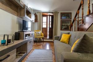 ein Wohnzimmer mit einem Sofa und einem TV in der Unterkunft Cantinho dos Avós in Viana do Castelo