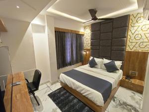 a bedroom with a bed and a desk and a bed sidx sidx sidx at Hotel Prime Villa Gurukul in Ahmedabad