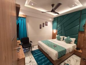 Hotel Prime Villa Gurukul في أحمد آباد: غرفة نوم مع سرير مع اللوح الأمامي الأخضر