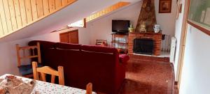 a living room with a couch and a fireplace at Apartamento abuhardillado en pueblo asturiano in Santianes