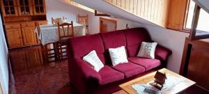 a living room with a purple couch and a table at Apartamento abuhardillado en pueblo asturiano in Santianes