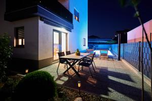 een tafel en stoelen op een patio in de nacht bij ZEN apartment in Trogir