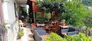 a patio with chairs and tables and plants at Apartamento abuhardillado en pueblo asturiano in Santianes