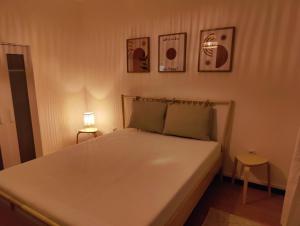 ein Schlafzimmer mit einem großen weißen Bett mit einer Lampe in der Unterkunft Bliss - 3 Zimmer, Boho, Arbeitsplatz, Netflix in Gießen
