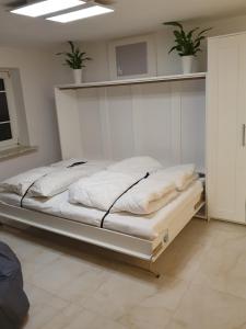 ブラウンラーゲにあるMikes Fewoの鉢植えの植物2本が備わる部屋の白いベッド1台