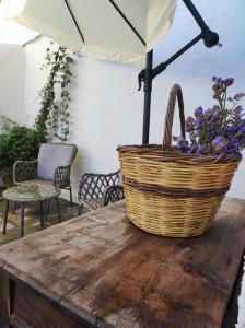 un cesto di fiori seduto su un tavolo con ombrellone di Giorgio studios a Kokkari