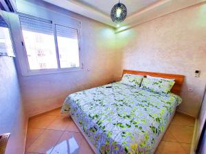 um quarto com uma cama e uma janela em great location flat Calm & Chocolat gift em Agadir