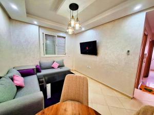 uma sala de estar com um sofá e uma mesa em great location flat Calm & Chocolat gift em Agadir