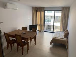 Una sala de estar con una mesa de madera y un sofá. en Dpto Bastion del Este 103, en Tandil